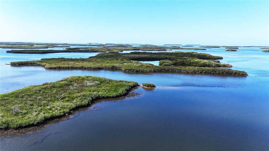 An aerial view of mangrove islands surrounded by calm blue water under a clear sky — 15410 W ST MARTINS ROAD, CRYSTAL RIVER, FL