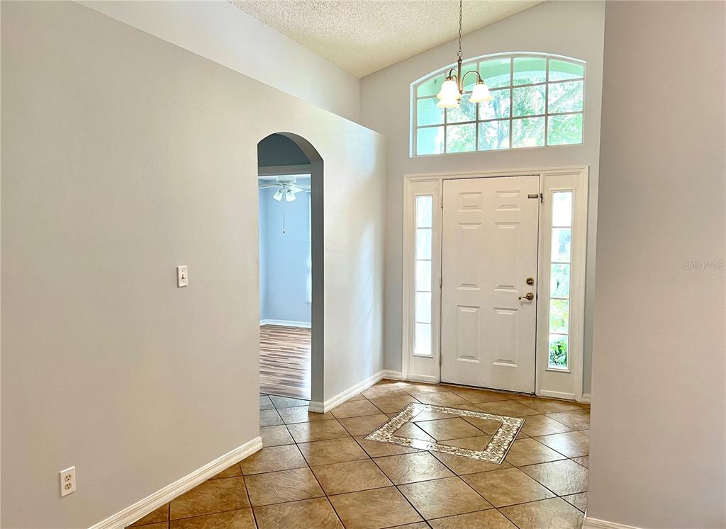 An entryway with tile flooring, a vaulted ceiling, and a white front door with sidelights — 80 PINE FOREST PLACE, APOPKA, FL