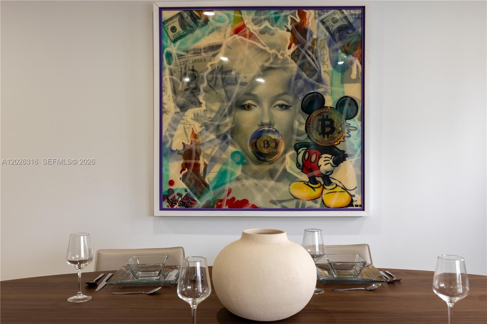 A dining room features a wooden table with place settings and a large pop-art painting — 1975 Calais Dr # 4, Miami Beach FL 33141, MIAMI BEACH, FL