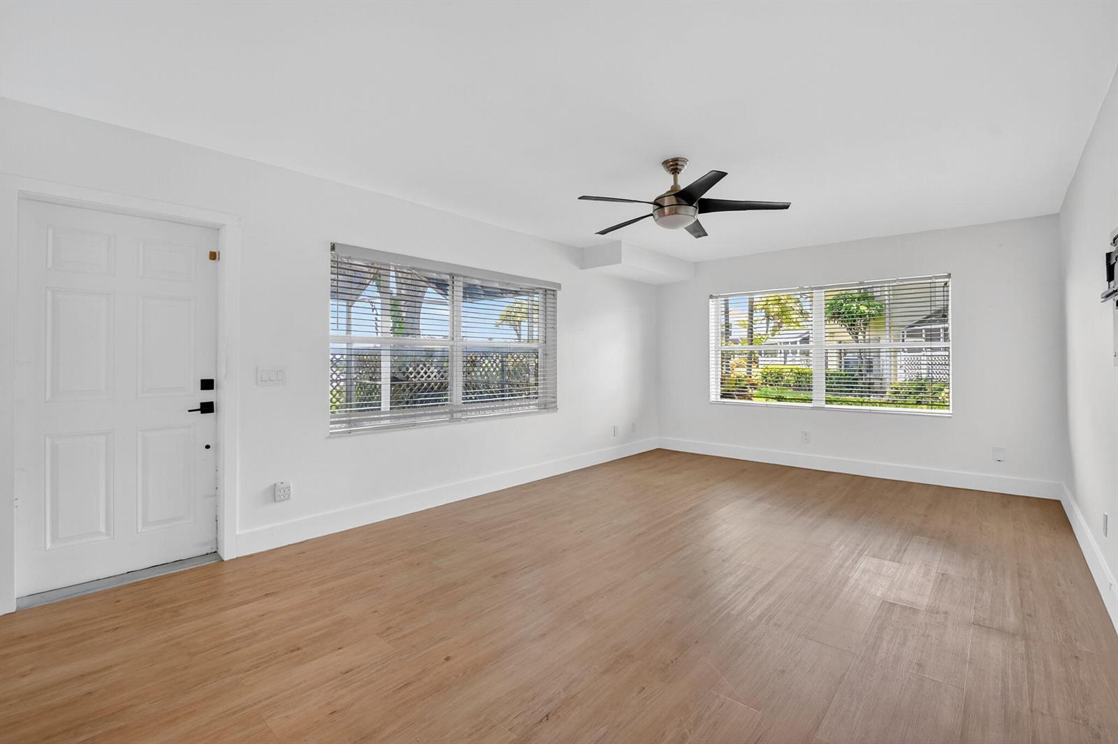 An empty room with white walls, light wood-look flooring, two windows, and a ceiling fan — 3404 Hayden Court, Boynton Beach FL 33436, BOYNTON BEACH, FL