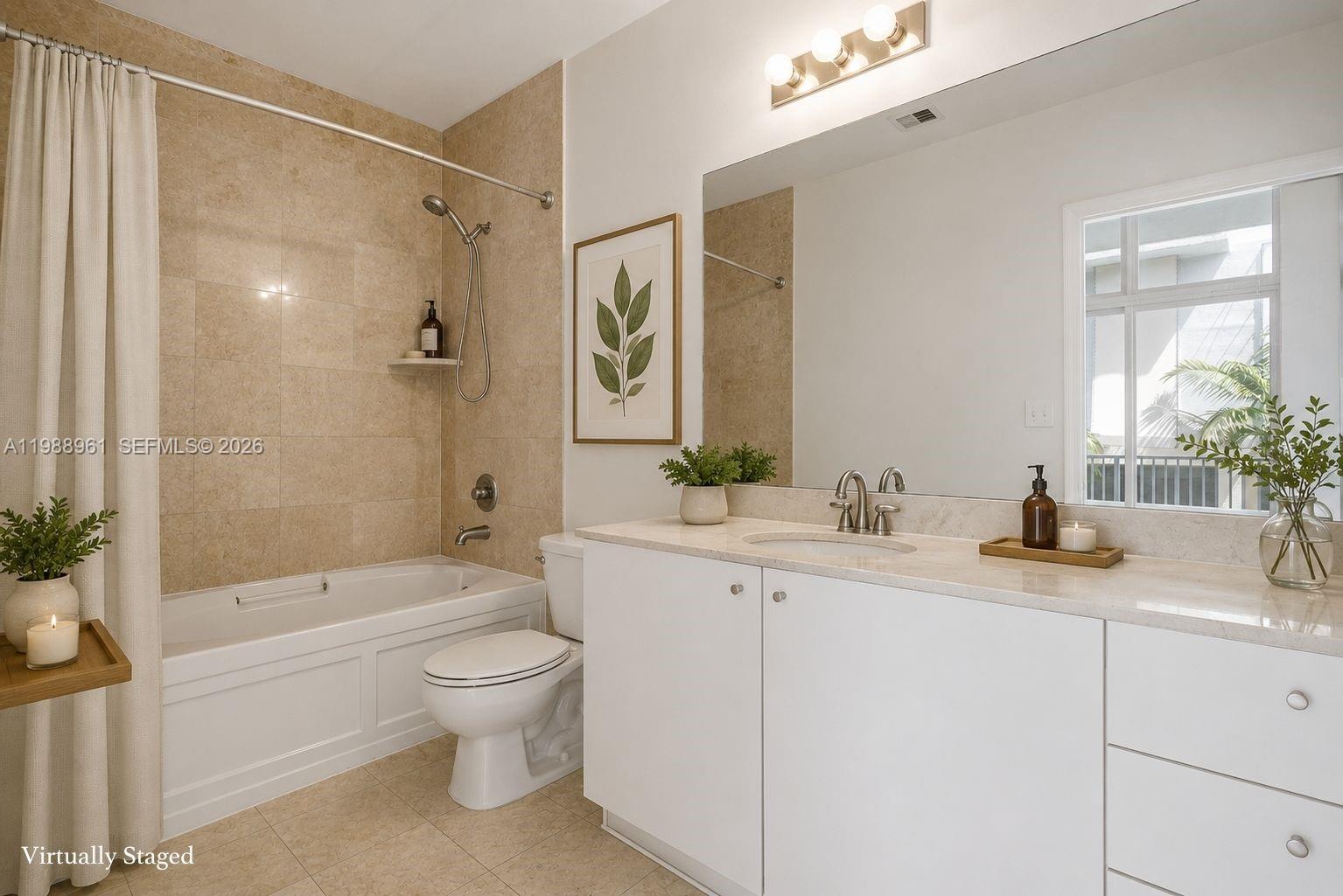 A bathroom features a white vanity, a beige tiled tub surround, and a large mirror — 2100 Van Buren St # 319, Hollywood FL 33020, HOLLYWOOD, FL