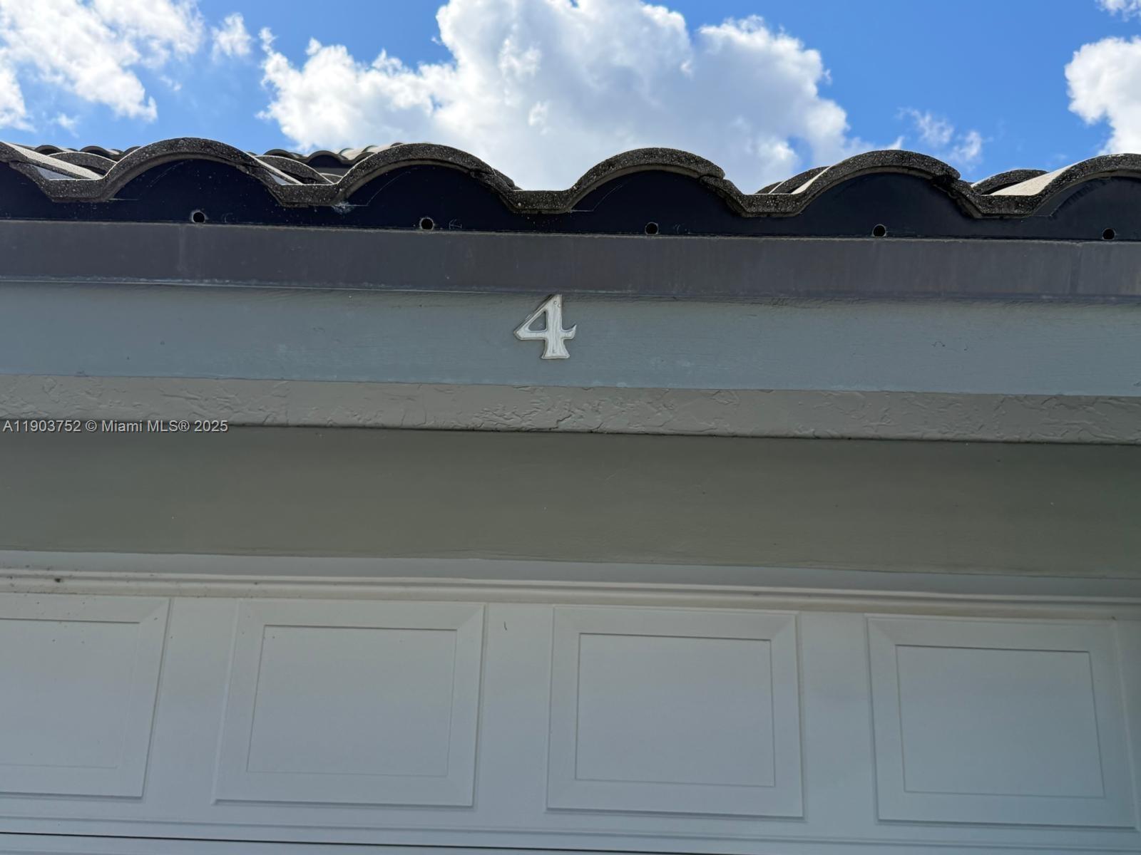 The number four is mounted on the exterior wall above a white garage door — 11690 Briarwood Cir # 4, Boynton Beach FL 33437, BOYNTON BEACH, FL