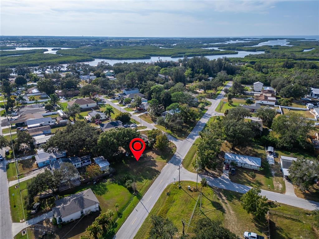 An aerial view shows a vacant lot marked with a red pin in a residential neighborhood — 1104 W COLLEGE AVENUE, RUSKIN, FL