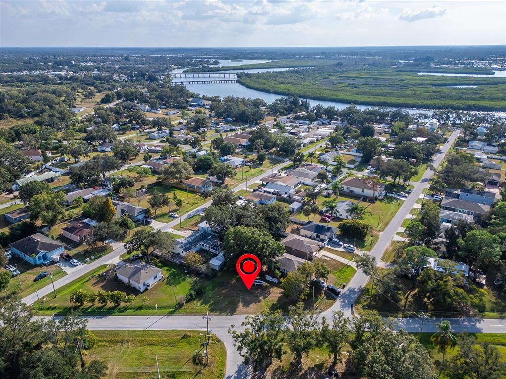 An aerial view shows a residential lot marked with a red pin near a waterway — 1104 W COLLEGE AVENUE, RUSKIN, FL