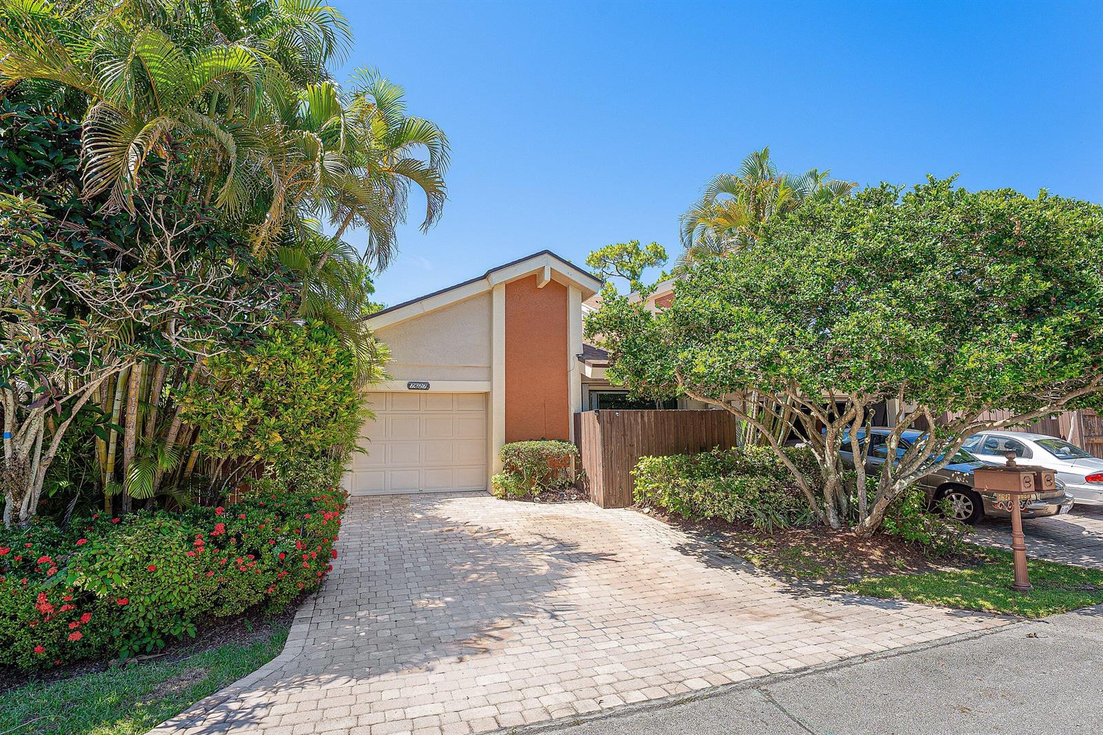 A single-story house with a paved driveway, a garage, and lush landscaping under a blue sky — 7627 Sierra Drive W, Boca Raton FL 33433, BOCA RATON, FL