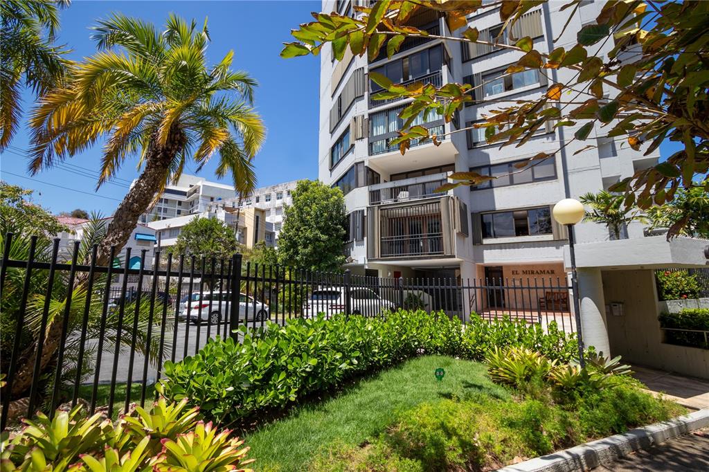 A multi-story apartment building with balconies and a fenced parking area surrounded by palm trees — 610 AVE. MIRAMAR UNIT 5-B, SAN JUAN, PR