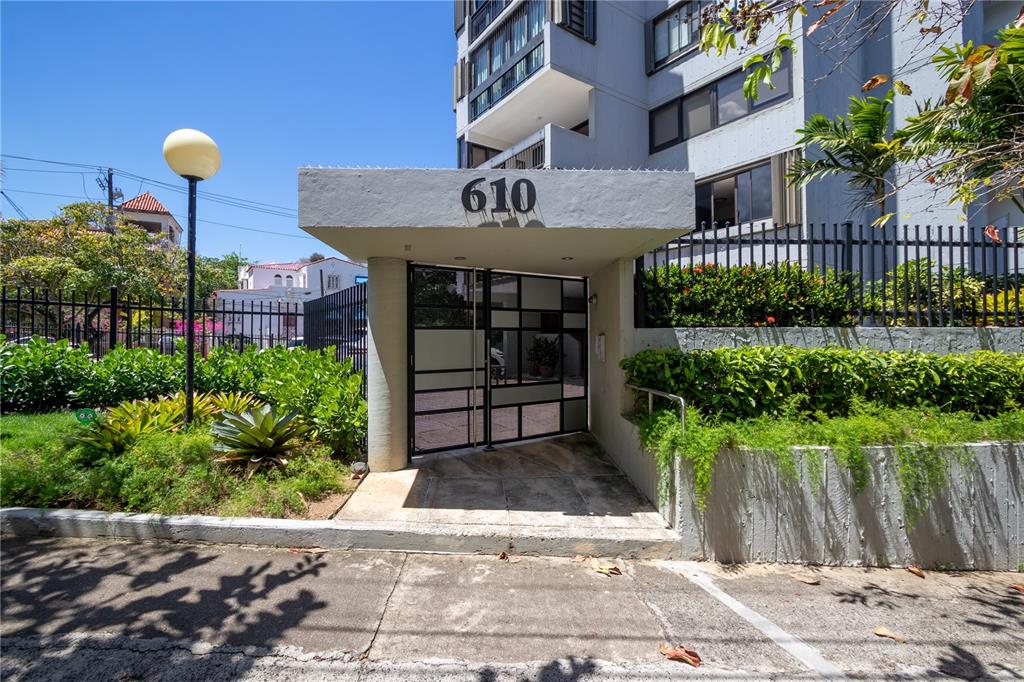 The exterior entrance of a multi-story apartment building features a gated walkway labeled 610 — 610 AVE. MIRAMAR UNIT 5-B, SAN JUAN, PR