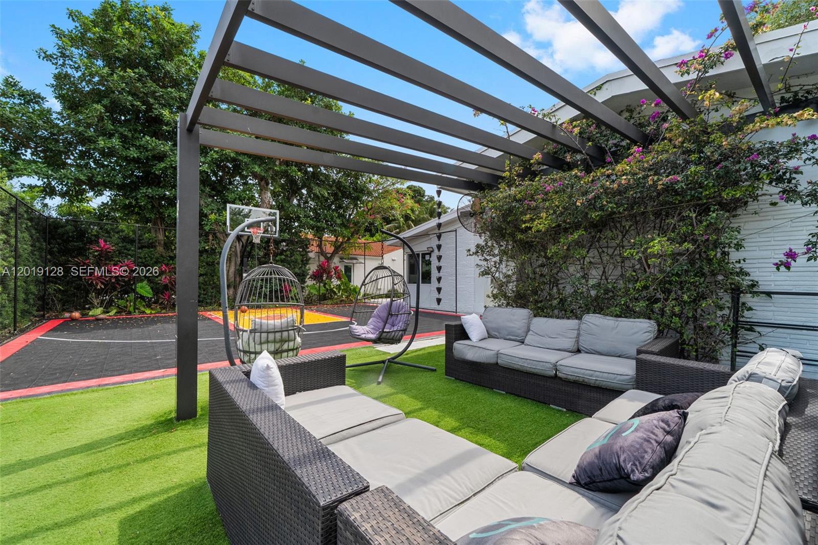 An outdoor patio features a pergola, wicker furniture, and a basketball court on artificial turf — 3758 Prairie Ave, Miami Beach FL 33140, MIAMI BEACH, FL