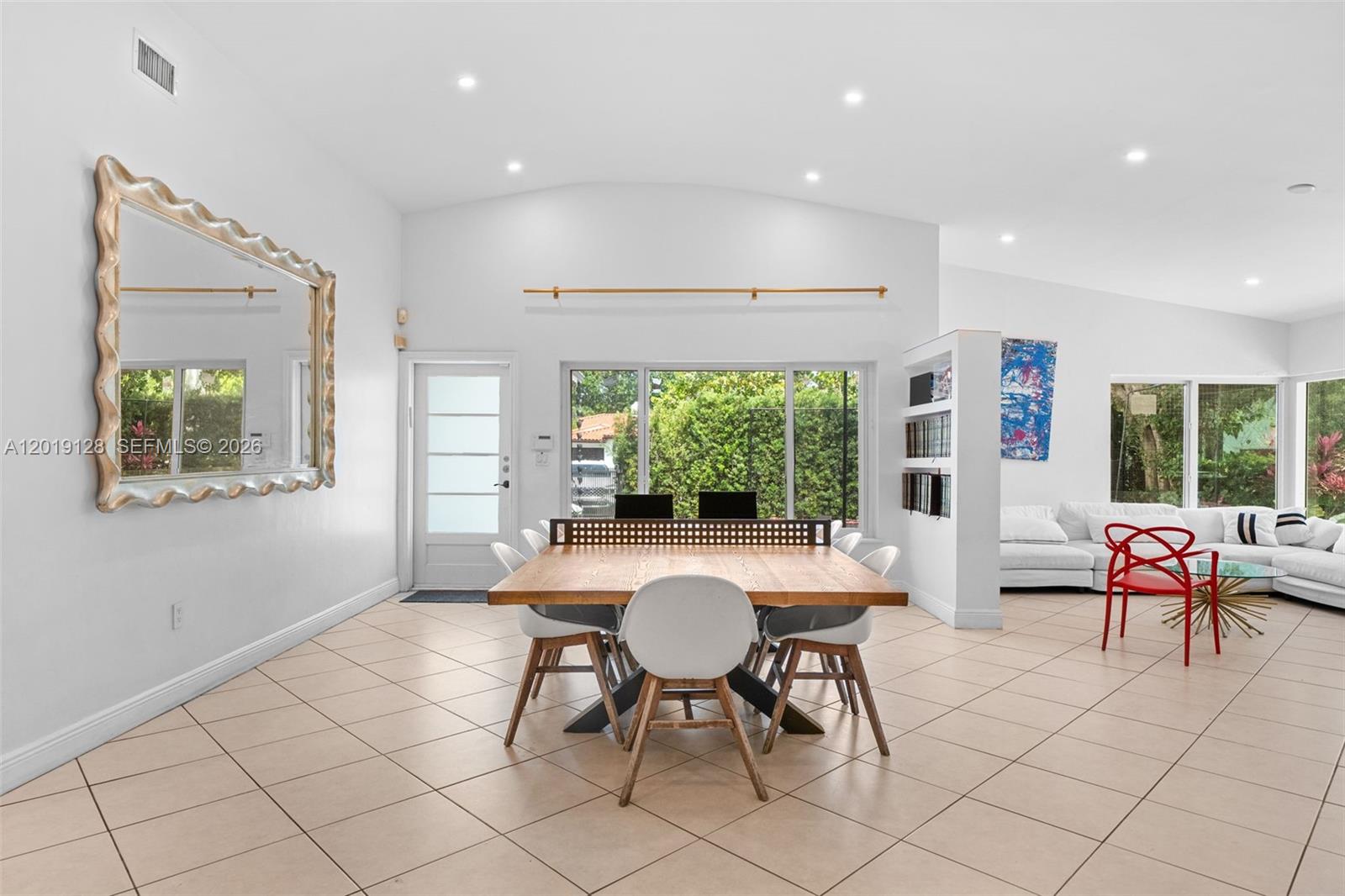 A dining area features a wooden table, white chairs, a large mirror, and tiled flooring — 3758 Prairie Ave, Miami Beach FL 33140, MIAMI BEACH, FL