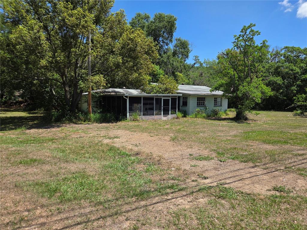 A single-story house with a screened-in porch sits on a large, grassy lot — 3810 E LUMSDEN ROAD, VALRICO, FL