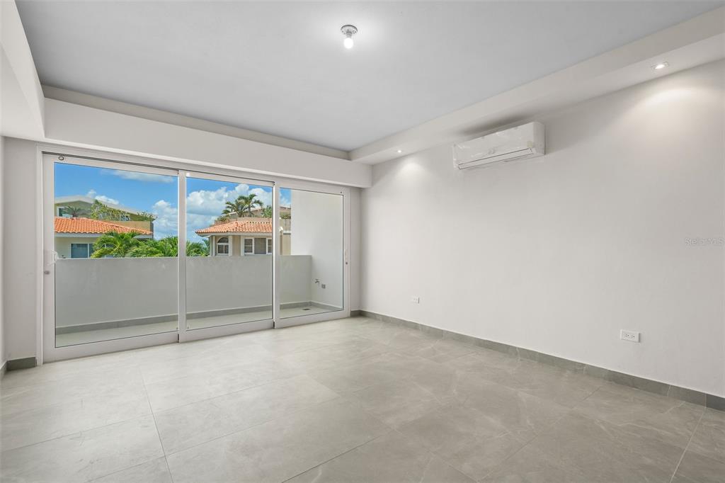 An empty room with light-colored tile floors, white walls, a ceiling light, and sliding glass doors — . SHELL CASTLE CLUB UNIT 46, HUMACAO, PR