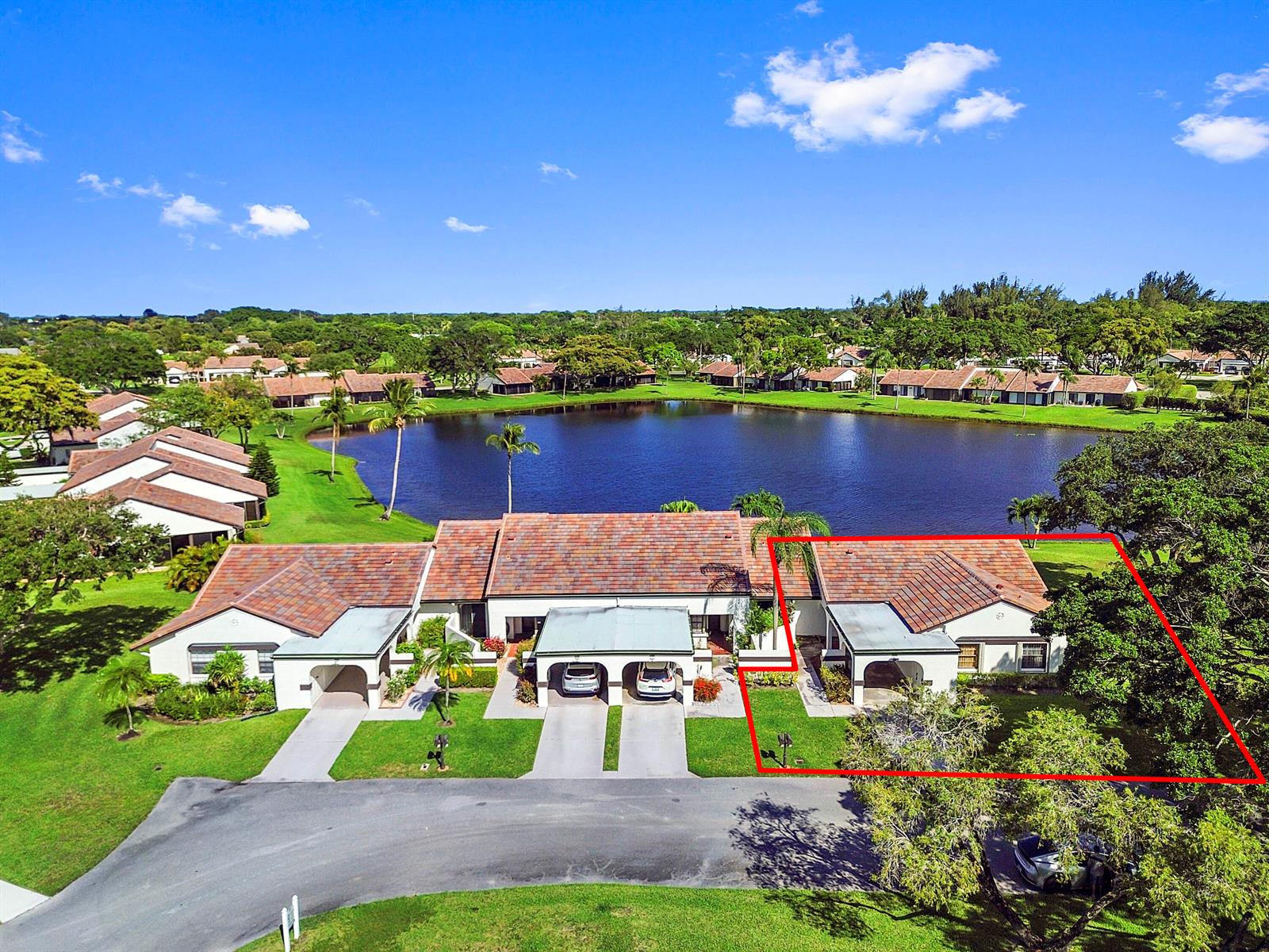 An aerial view of a residential building with a red-tiled roof beside a lake — 5537 Parkwalk Circle E, Boynton Beach FL 33472, BOYNTON BEACH, FL