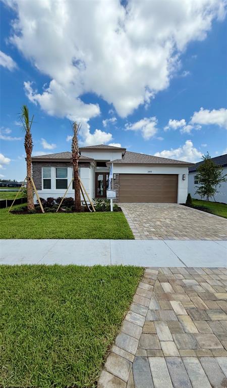 A single-story house with a stone facade, a two-car garage, and a paved driveway — 3419 MALTA AVENUE, WESLEY CHAPEL, FL