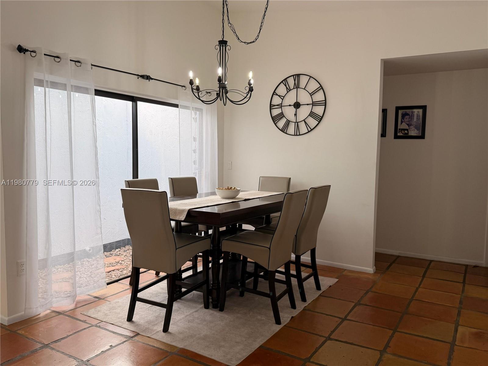A dining room features a dark wood table, six chairs, a chandelier, and tile flooring — 6641 NW 174th Ter, Hialeah FL 33015, HIALEAH, FL