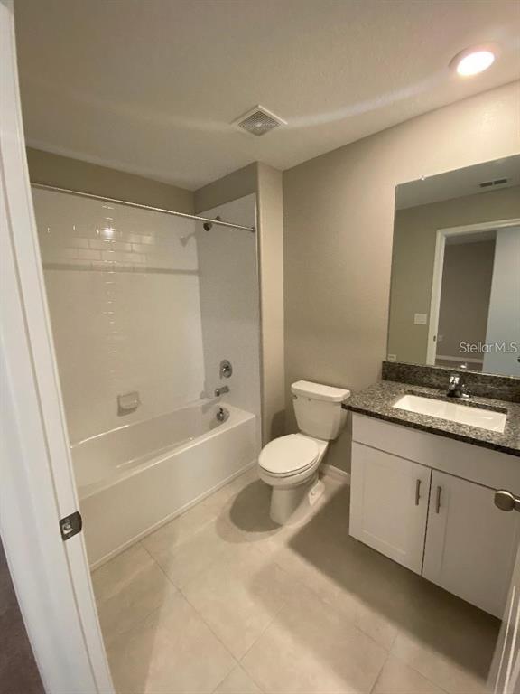 A bathroom features a white tub-shower combo, a toilet, and a vanity with a sink — 2179 AZURE VIEW WAY, LUTZ, FL