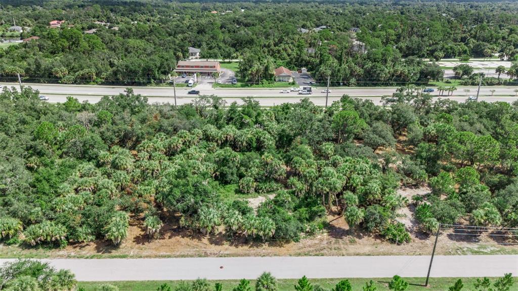 An aerial view shows a wooded lot situated between two paved roads — 16220 FRANKLIN AVENUE, PORT CHARLOTTE, FL