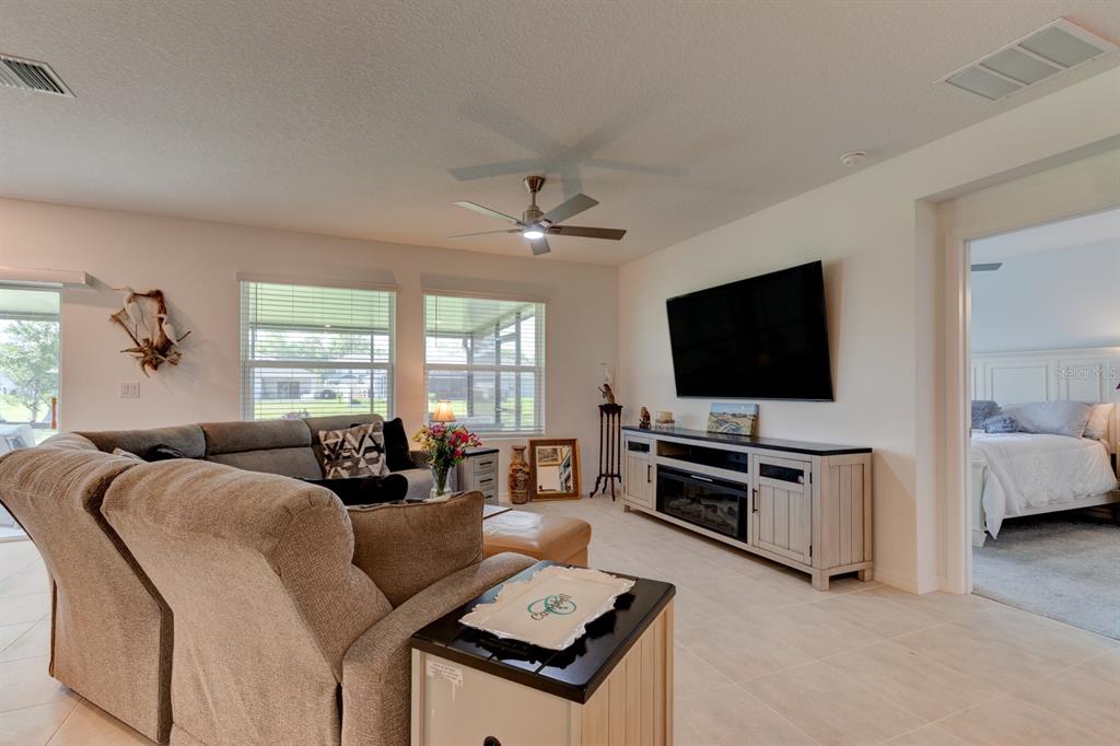 A living room features a sectional sofa, a television on a console, and tile flooring — 176 JONES FISH CAMP ROAD, EDGEWATER, FL