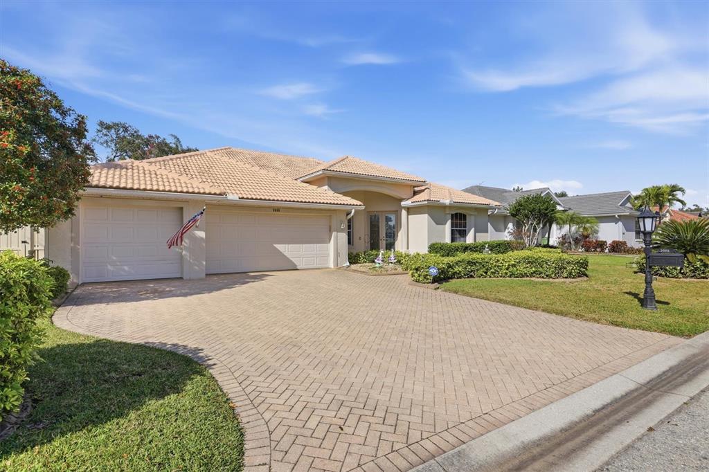 A one-story house with a tiled roof, a paved driveway, and a two-car garage — 5608 EASTWIND DRIVE, SARASOTA, FL