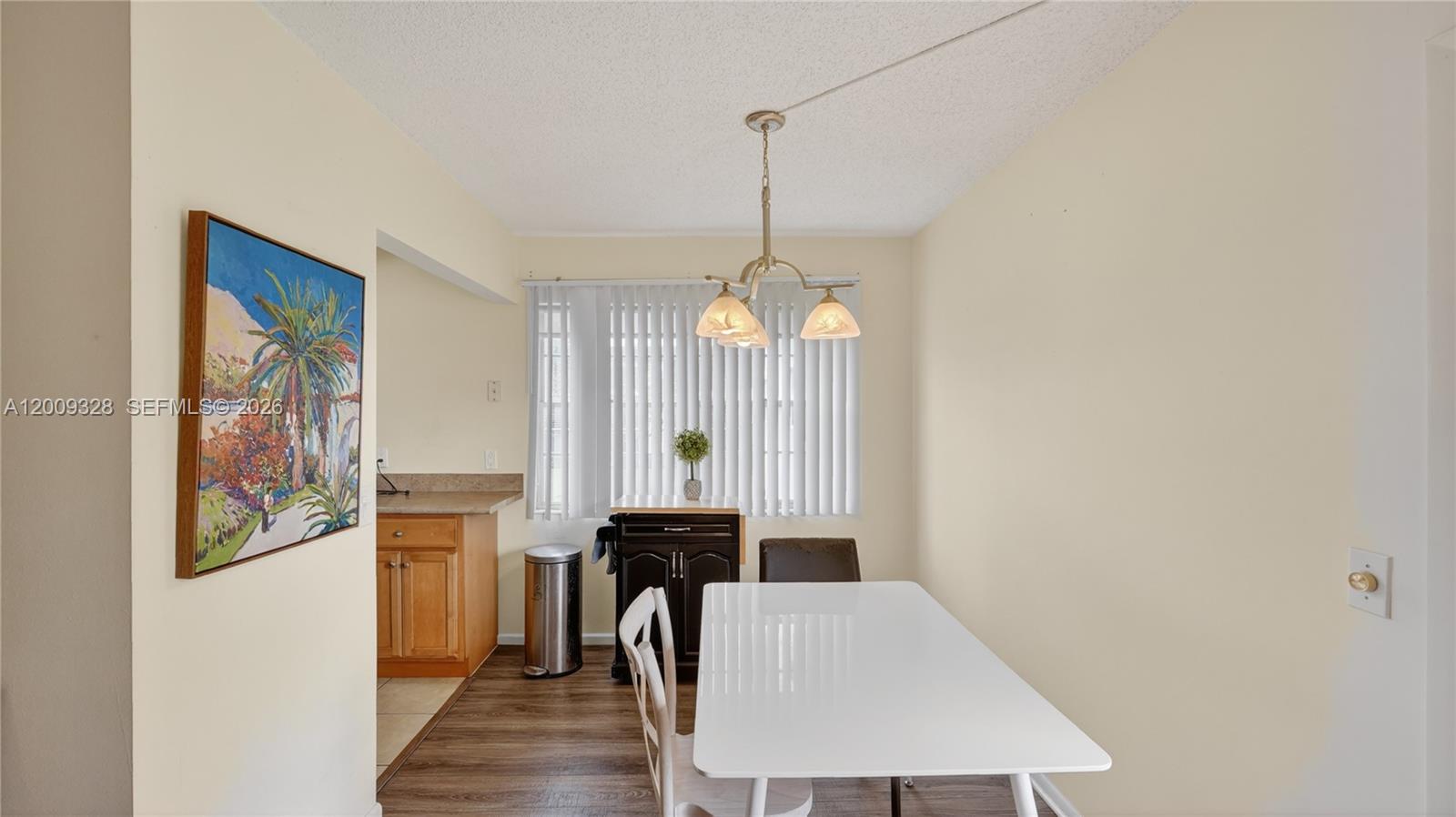 A dining area features a white table, a pendant light, and a window with blinds — 438 Mansfield K # 438, Boca Raton FL 33434, BOCA RATON, FL