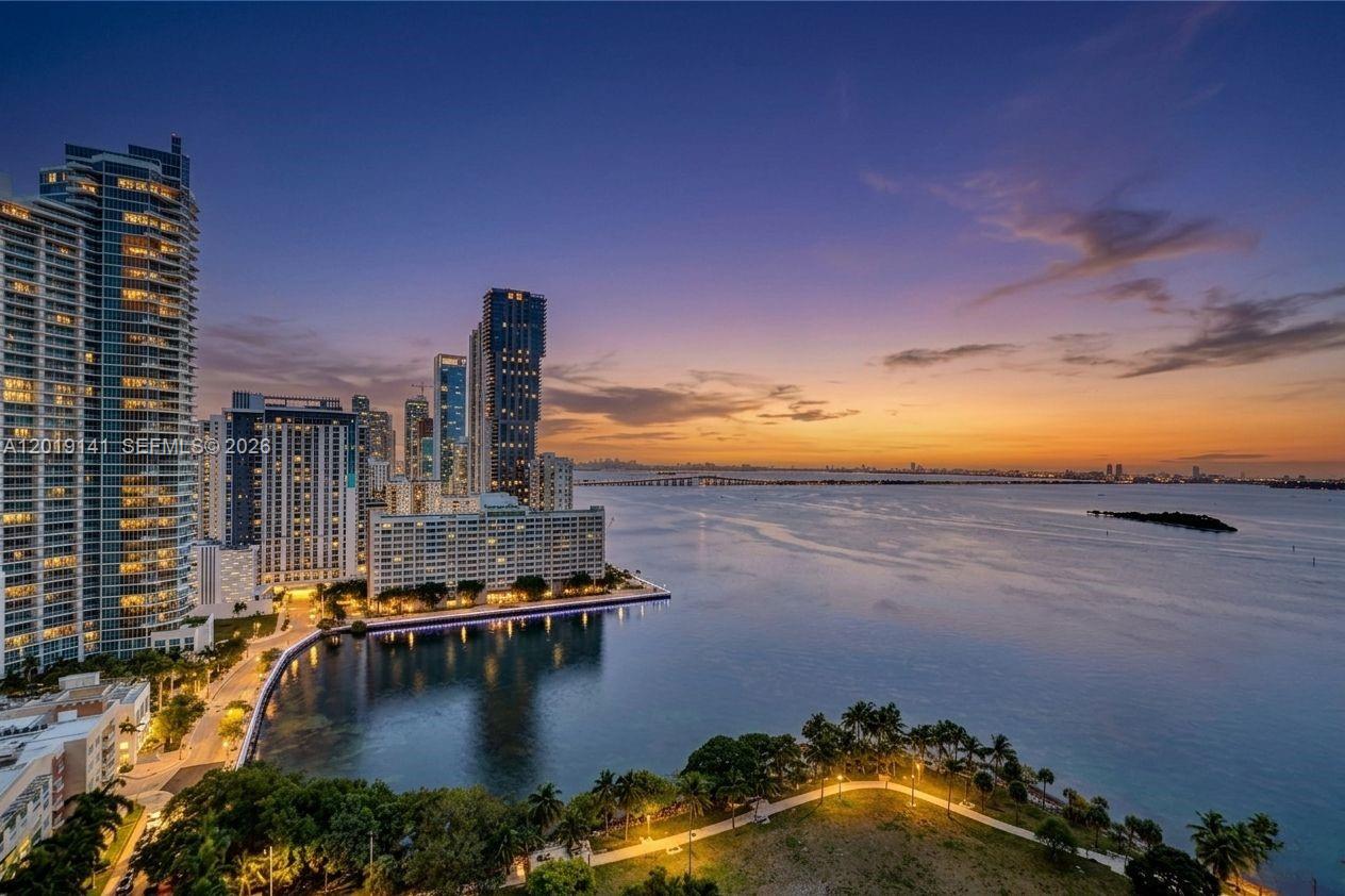 An aerial view of a waterfront city skyline at sunset with high-rise buildings and palm trees — 1900 N Bayshore Dr # 2204, Miami FL 33132, MIAMI, FL