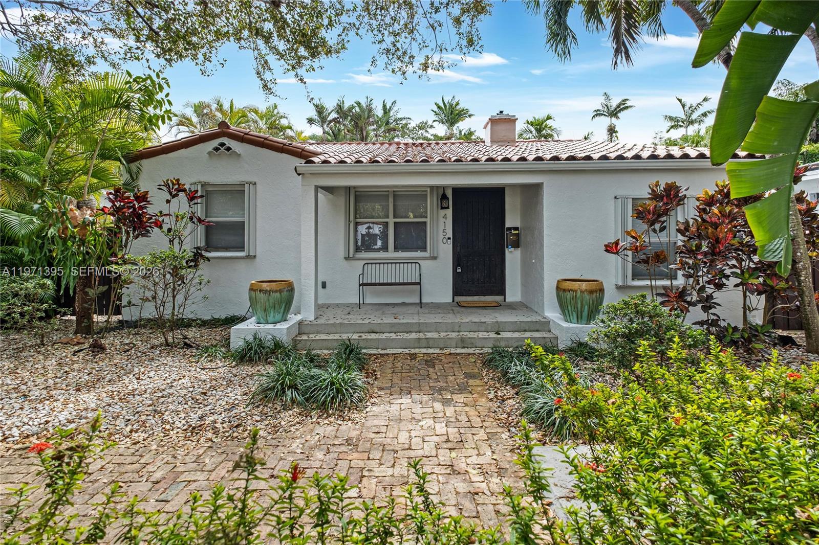A single-story white stucco house features a red tile roof and a brick walkway — 4150 Ventura Ave, Miami FL 33133, MIAMI, FL