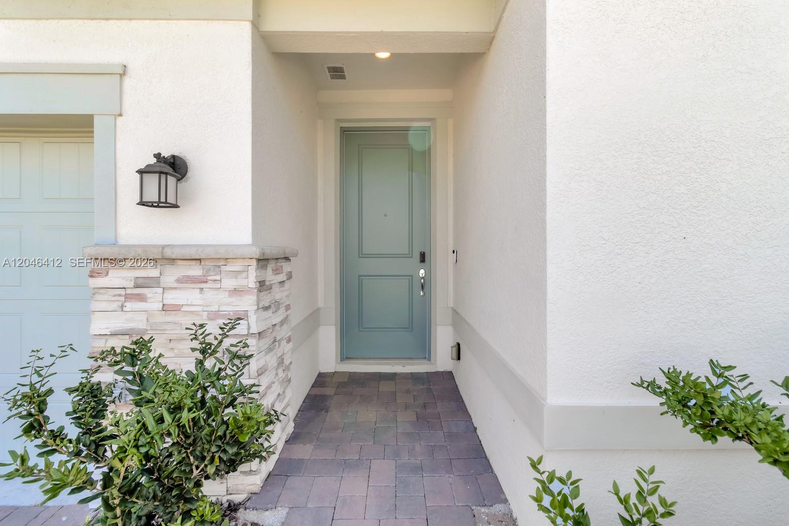 A light blue front door is set within a stucco entryway with stone accents — 2081 MOSSY VINE AV, Saint Cloud FL 34771, SAINT CLOUD, FL
