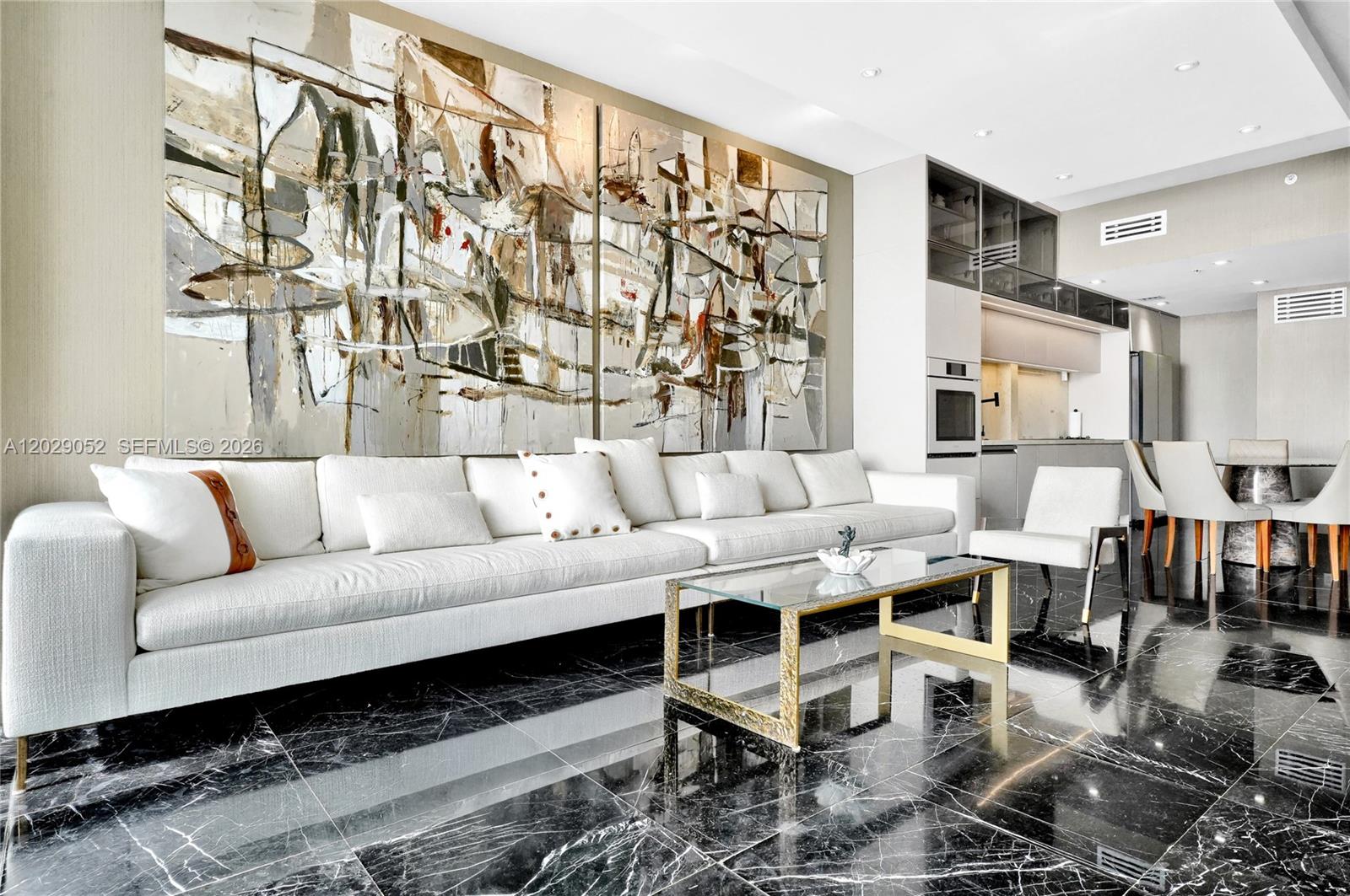 A modern living room features a large abstract painting, white sofa, and black marble floors — 725 NE 22nd St # 11E, Miami FL 33137, MIAMI, FL