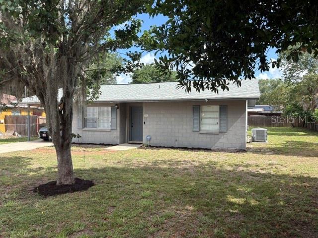 A single-story concrete block house with a gray roof sits on a grassy lot — 506 W 9TH STREET, FROSTPROOF, FL