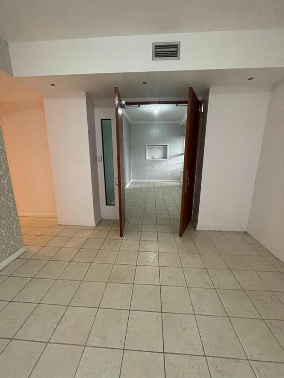 A room with light-colored tile flooring leads through double wooden doors into another tiled space — 200 JESUS T PINEIRO AVENUE AVENUE, SAN JUAN, PR