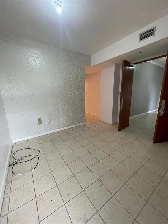 A room with light-colored tile flooring, a patterned accent wall, and an open wooden doorway — 200 JESUS T PINEIRO AVENUE AVENUE, SAN JUAN, PR