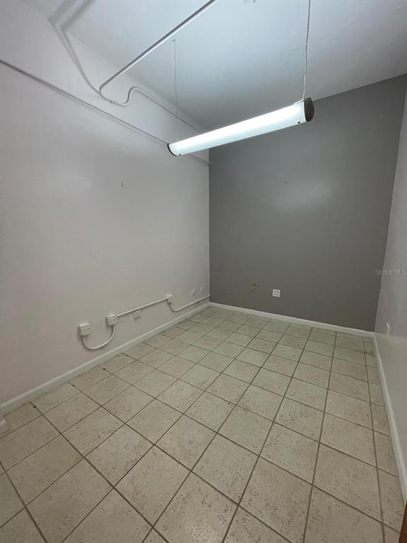 An empty room features light-colored tile flooring, a suspended light fixture, and exposed electrical conduit — 200 JESUS T PINEIRO AVENUE AVENUE, SAN JUAN, PR