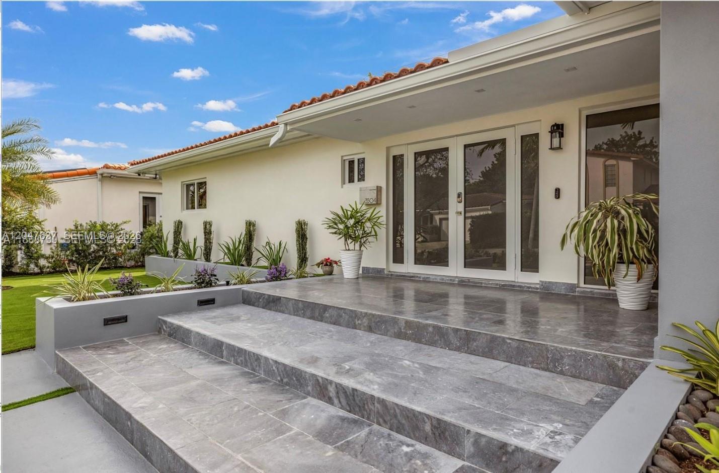 A modern house entrance features wide gray stone steps leading to a glass double door — 3504 Crystal View Ct # 0, Miami FL 33133, MIAMI, FL