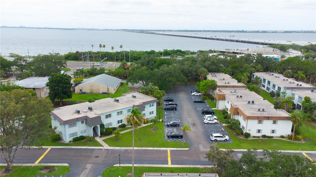 An aerial view shows two apartment buildings with parking lots and a bridge over water — 389 S MCMULLEN BOOTH ROAD UNIT 12, CLEARWATER, FL