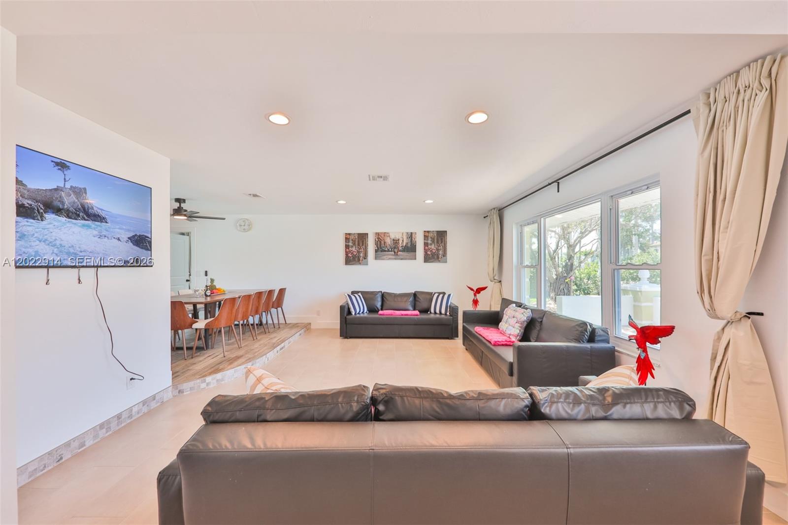A living room features dark leather sofas, a wall-mounted television, and an adjacent dining area — 209 Bayshore Dr, Cape Coral FL 33904, CAPE CORAL, FL