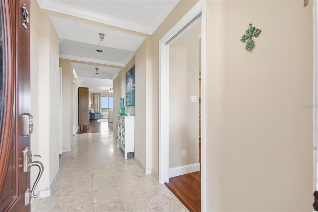 A tiled entryway leads to a hallway with a white cabinet and distant living area — 11 AVENUE DE LA MER UNIT 1306, PALM COAST, FL