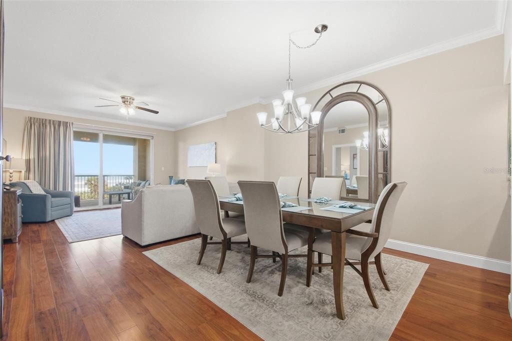 A dining area with a wooden table and chairs sits next to a living room — 11 AVENUE DE LA MER UNIT 1306, PALM COAST, FL