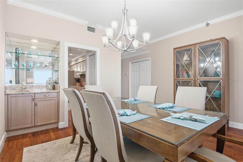 A dining room features a glass-topped table, a chandelier, a wet bar, and a china cabinet — 11 AVENUE DE LA MER UNIT 1306, PALM COAST, FL