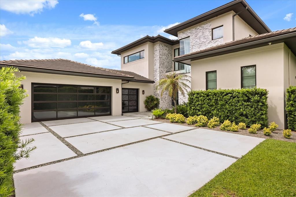 A modern two-story house with a multi-car garage and a concrete paver driveway — 10348 KENSINGTON SHORE DRIVE, ORLANDO, FL