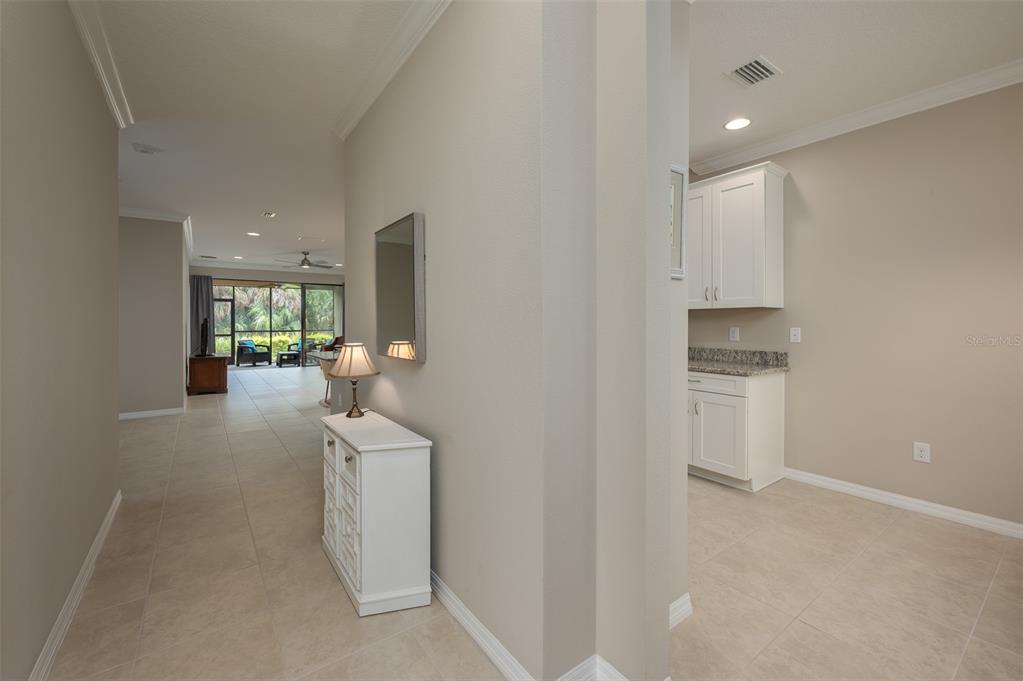 A kitchen with granite countertops and white cabinets overlooks an open-concept living and dining area — 5425 CICERONE STREET UNIT 101, SARASOTA, FL