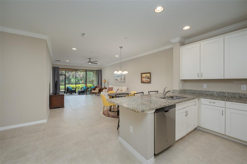 A living and dining area with tile floors, a white sofa, and a round table — 5425 CICERONE STREET UNIT 101, SARASOTA, FL