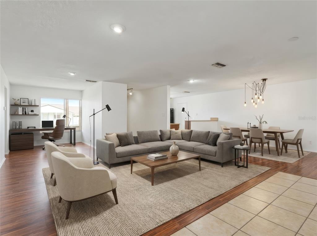 An open-concept living and dining area features a sectional sofa, wood flooring, and a desk — 10823 WILLIAM AND MARY COURT, ORLANDO, FL