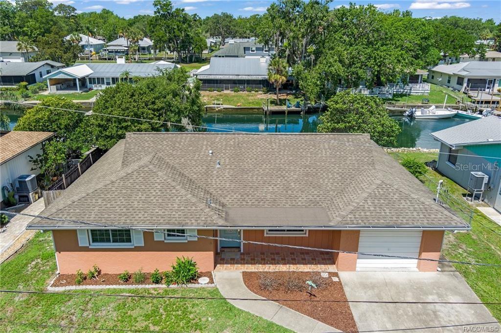 An aerial view of a single-story house with a brown roof and a canal behind — 1400 SE 5TH AVENUE, CRYSTAL RIVER, FL