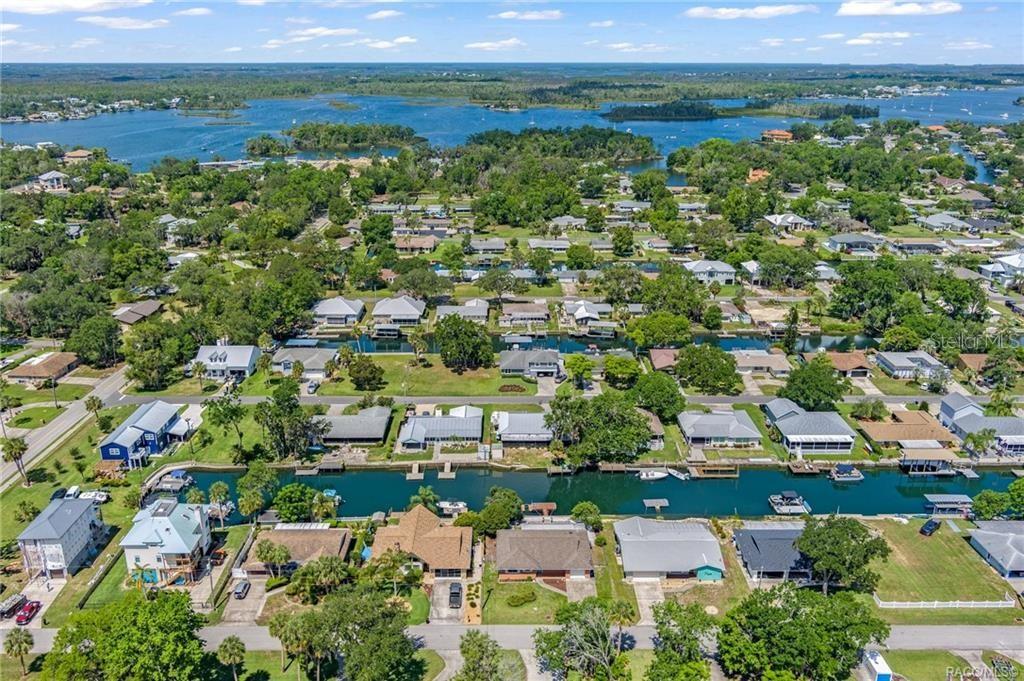 An aerial view shows a residential neighborhood with houses situated along a canal and bay — 1400 SE 5TH AVENUE, CRYSTAL RIVER, FL