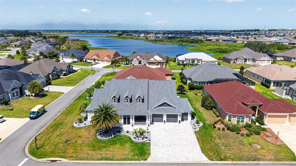 An aerial view shows a suburban house with a gray roof and a paved driveway — 3468 MCDANIEL PLACE, THE VILLAGES, FL