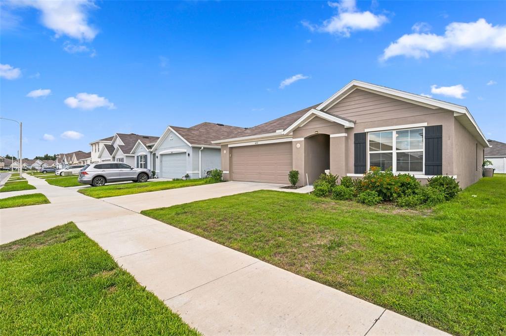 A tan single-story house with a two-car garage and a concrete driveway — 4052 AUTUMN AMBER DRIVE, SPRING HILL, FL