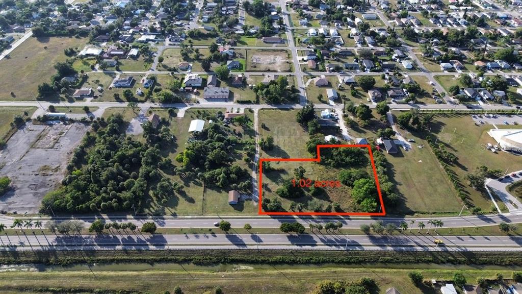 An aerial view shows a vacant, partially wooded lot outlined in red along a road — 3550 S GRIMSLEY COURT, FORT MYERS, FL