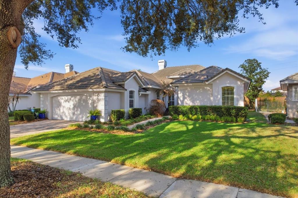 A single-story house with a tiled roof, two-car garage, and a manicured front lawn — 10926 WOODCHASE CIRCLE, ORLANDO, FL
