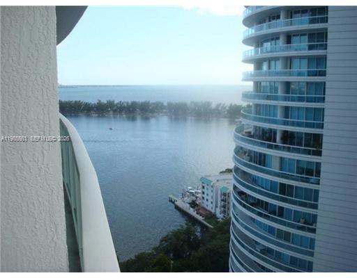 A high-angle view from a balcony overlooking a bay and a neighboring high-rise building — 2101 Brickell Ave # 1911, Miami FL 33129, MIAMI, FL