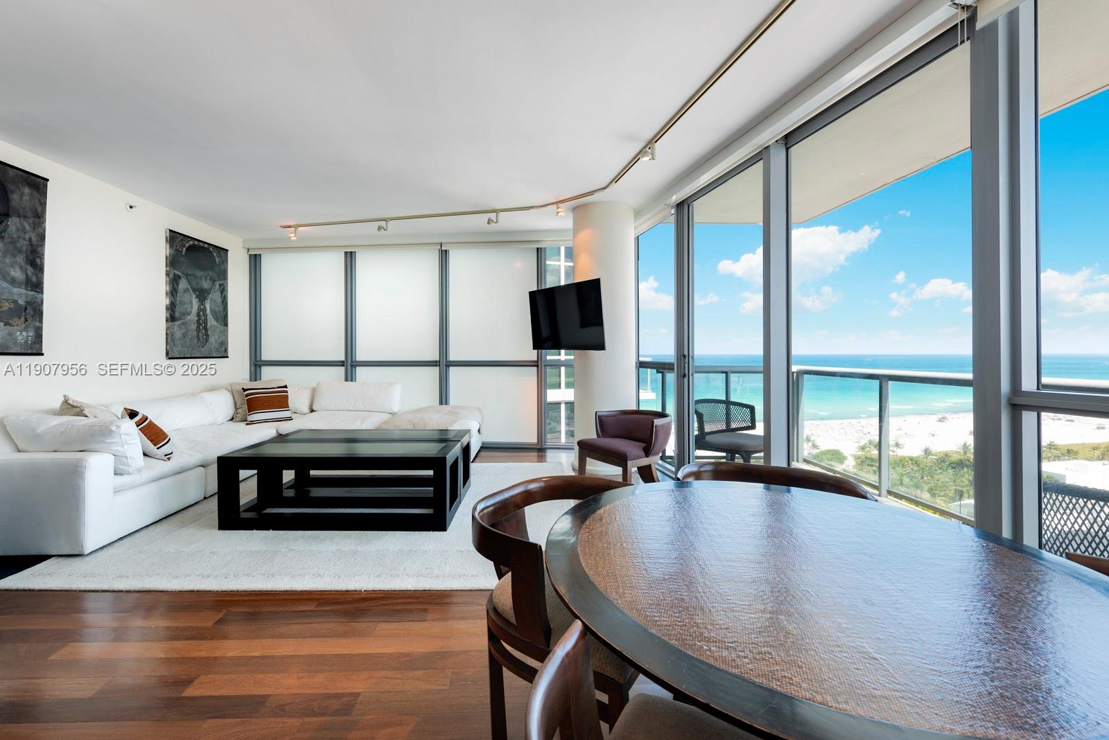 A modern living and dining area features floor-to-ceiling windows with an ocean view — 101 20th St # 2004, Miami Beach FL 33139, MIAMI BEACH, FL