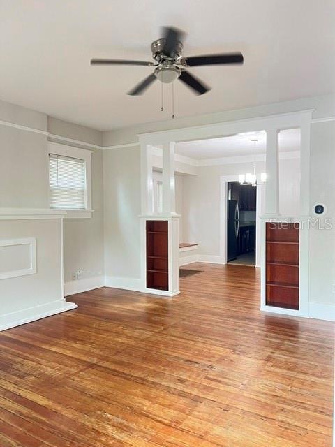 A living room with hardwood floors, a ceiling fan, and built-in shelving flanking a doorway — 143 N STONE STREET UNIT N, DELAND, FL